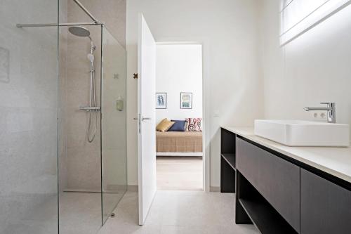 uma casa de banho com uma cabina de duche em vidro e um lavatório. em Smartflats - Bell Tower Ghent em Gent
