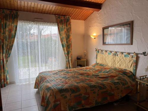 une chambre avec un lit et une grande fenêtre dans l'établissement Maison spacieuse 300m de la plage avec jardin clos, proche commerces et secteur calme - 8 pers - FR-1-224B-126, à La Guérinière