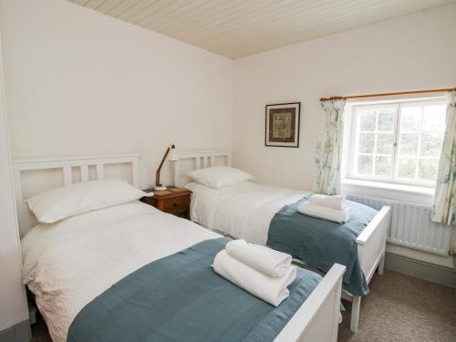 a bedroom with two beds and a window at 1 Hetfield Cottages in Bishops Castle
