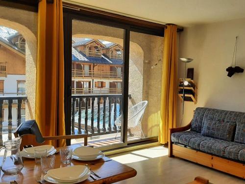 un salon avec une table et une grande fenêtre dans l'établissement Bel appartement 3 pièces pour 7 pers avec balcon, Montgenèvre - FR-1-330D-126, à Montgenèvre