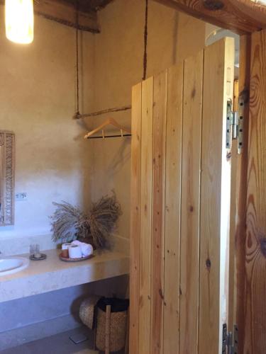 錫瓦的住宿－Tanirt ecolodge，一间带木门和水槽的浴室