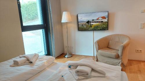 ein Wohnzimmer mit einem Bett und einem Stuhl in der Unterkunft Potenberg 4a by Rujana in Binz