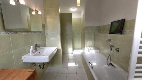 ein Badezimmer mit einem Waschbecken und einer Badewanne in der Unterkunft Potenberg 4a by Rujana in Binz