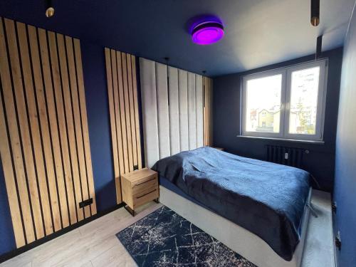um quarto com paredes azuis, uma cama e uma janela em Galaxy Space, Sopot Centre and Beach em Sopot