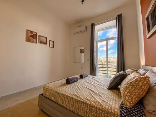 a bedroom with a bed with a large window at Unique two bedrooms apartment 6 in Il-Gżira