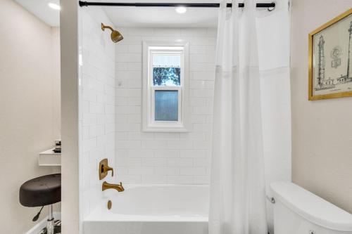 uma casa de banho branca com uma cortina de chuveiro e um lavatório. em La Niña Nokomis Beach & Venice Island Fenced In Yard em Nokomis