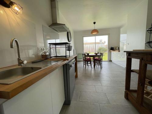 une cuisine avec un évier et une table avec des chaises dans l'établissement Maison 3 Pièces Calme Près Océan & Phare - 6 Couchages - WIFI, Parking - FR-1-246A-186, à Saint-Denis-dʼOléron