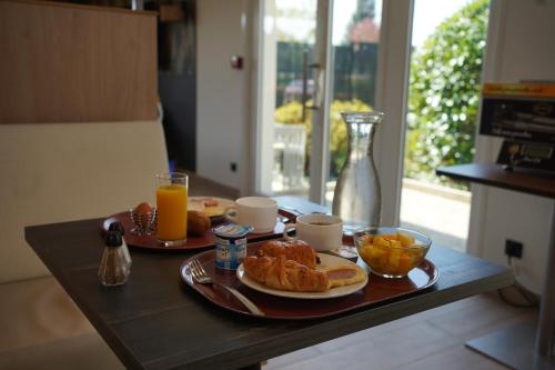 a table with two plates of breakfast foods and orange juice at Campanile Troyes Sud - Buchères in Troyes