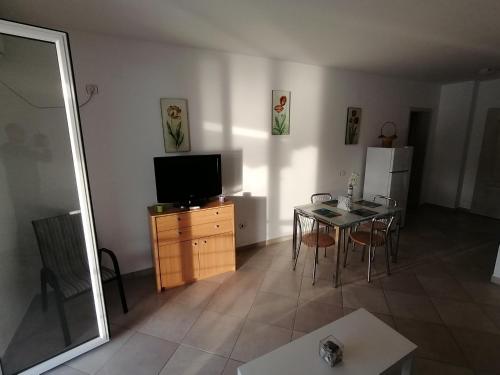 ブドヴァにあるLuxury Apartment Astelmnのリビングルーム(テレビ、テーブル、椅子付)