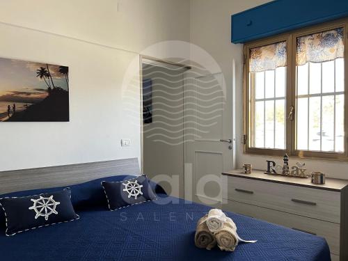 una camera da letto con un letto blu e una finestra di Villa Antonietta By Cala Salento a Punta Prosciutto