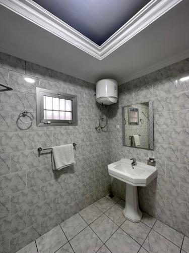布拉薩維爾的住宿－Hotel de l'Aeroport，白色的浴室设有水槽和窗户。