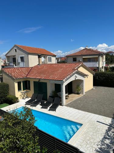 a swimming pool in front of a house at Villa a&a in Biograd na Moru