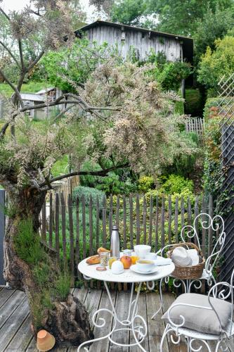 a table and chairs on a deck with a tree at Le Florida Auberge contemporaine in Castéra-Verduzan
