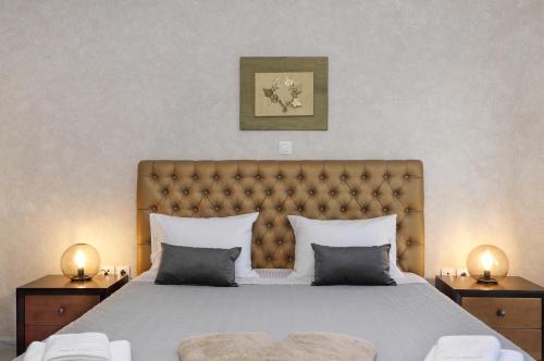 a bedroom with a large bed with a tufted headboard at Heliopetra Lux Villa with private Pool in Varípetron