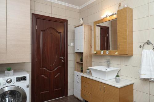 a bathroom with a washing machine and a sink at Heliopetra Lux Villa with private Pool in Varípetron