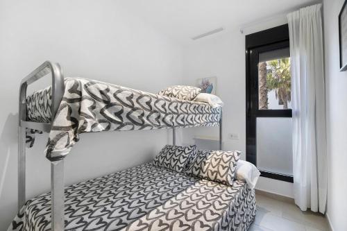 a room with two bunk beds and a couch at Apartamento Punta Candor in Rota