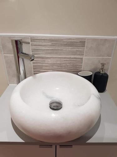 a white sink sitting on a counter in a bathroom at Bwthyn Eira in Llangefni