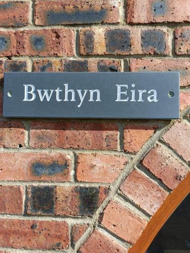 un cartel en una pared de ladrillo que dice que era en Bwthyn Eira en Llangefni