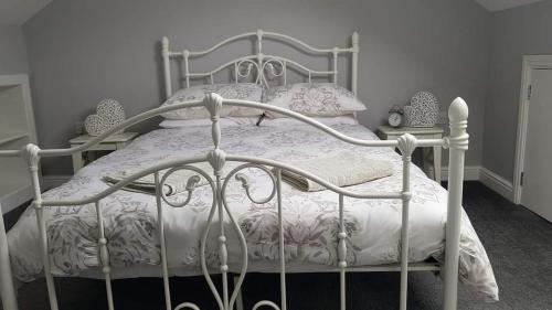 a bedroom with a white bed with a white comforter at Bwthyn Eira in Llangefni