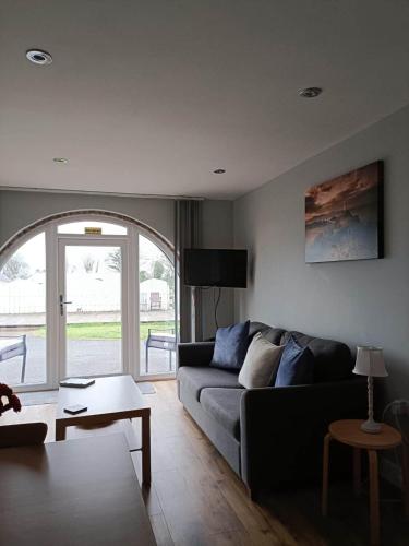 - un salon avec un canapé et une table dans l'établissement Bwthyn Eira, à Llangefni