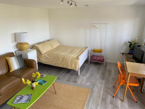 a living room with a bed and a couch and a table at The Little Cabin in St Ives