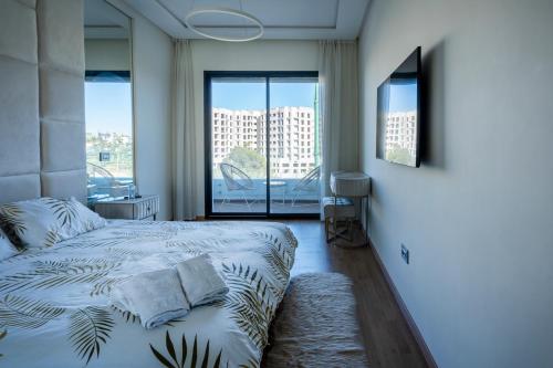 a bedroom with a bed and a large window at Paris-Oasis Casablanca avec piscine panoramique in Casablanca