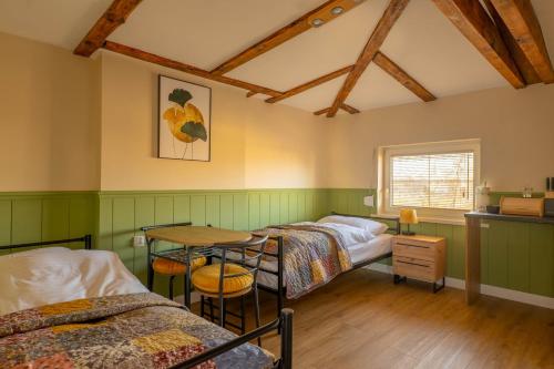 Zimmer mit 3 Betten und einem Tisch in der Unterkunft Villa Arkadia in Września