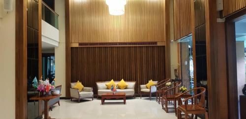 a lobby with couches and chairs in a building at Asia Hotels Group (Poonpetch Chiangmai) in Chiang Mai