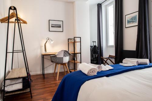 sypialnia z łóżkiem z niebieskim kocem w obiekcie Au coeur de Perpignan w Perpignanie