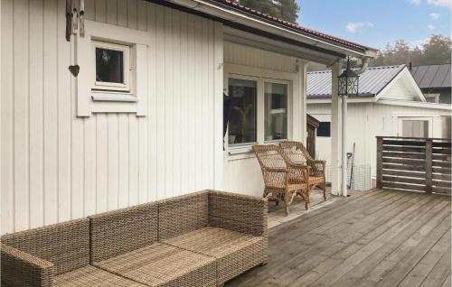 a wicker chair sitting on a porch of a house at Gorgeous Home In Skå With Kitchen in Skå