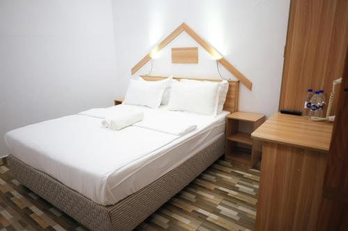 Schlafzimmer mit einem Bett mit weißer Bettwäsche und Kissen in der Unterkunft Golhaaviewinn in Thulusdhoo