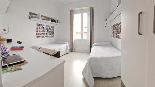 een witte kamer met 2 bedden en een bureau bij SPACE CENTER MADRID in Madrid