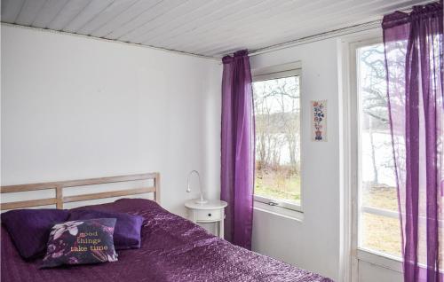 a bedroom with purple curtains and a bed and a window at Gorgeous Home In Lyckeby With House Sea View in Lyckeby