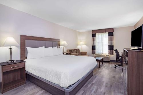 a hotel room with a bed and a television at Ramada by Wyndham Hendersonville in Hendersonville