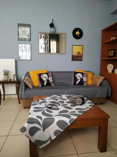 a living room with a couch and a table at Adorable Apartment in the center in Volos