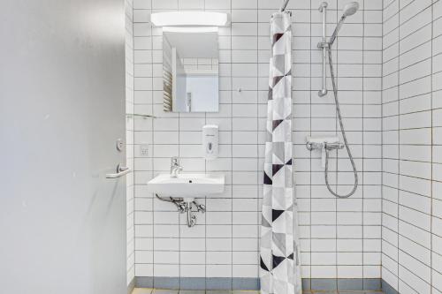 a bathroom with a sink and a shower at Danhostel Nørresundby Skansen in Nørresundby