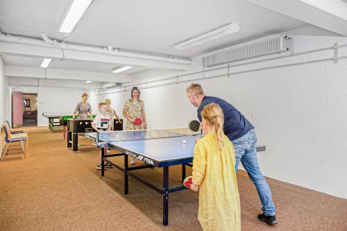 a man and a little girl playing ping pong at Danhostel Nørresundby Skansen in Nørresundby