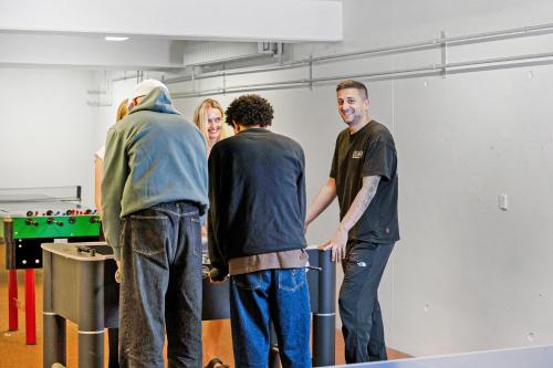 a group of three men standing in a room at Danhostel Nørresundby Skansen in Nørresundby