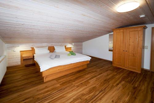 1 dormitorio con 1 cama grande en una habitación con suelo de madera en Ferienwohnung Wiesenlehen en Bischofswiesen
