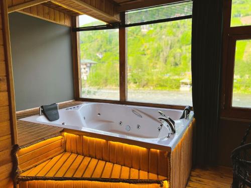 una grande vasca da bagno in una stanza con finestra di Heaven Wooden Vip Bungalow a Rize