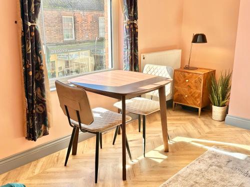 a table and two chairs in a room with a window at The Hudson in Market Weighton