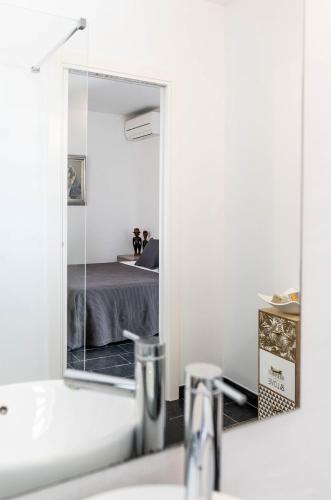 a bathroom with a mirror over a sink and a bed at Can Guasch in Sant Llorenç de Balafia