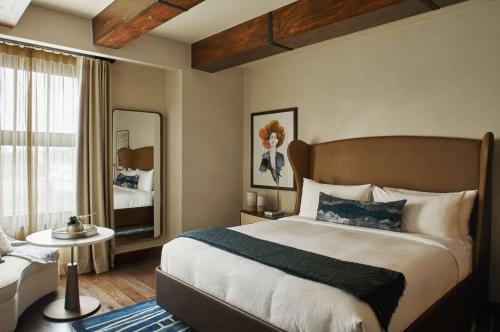 a bedroom with a large bed and a mirror at Hotel Figueroa, Unbound Collection by Hyatt in Los Angeles