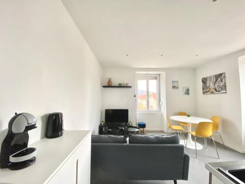 a living room with a couch and a table at Magnifique T2 40m2 lumineux, moderne et rénové avec fibre in Belfort