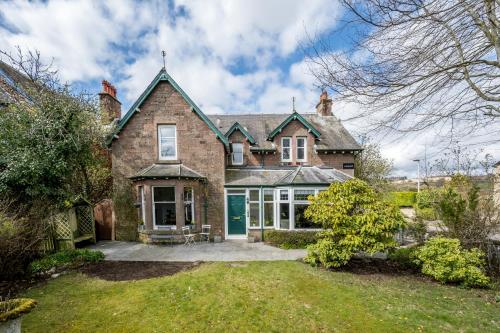 an exterior view of a brick house with a driveway at Luxury 5 bedroom Victorian home with Hot Tub in Blairgowrie
