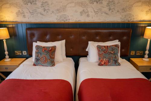 two beds with pillows on them in a bedroom at Berkshire Arms by Chef & Brewer Collection in Midgham