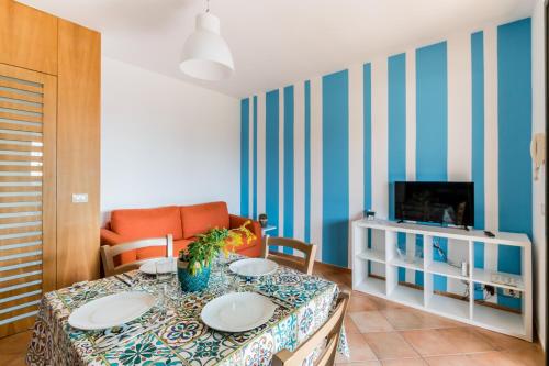 un soggiorno con tavolo e TV di Residence Andrea Doria a Marina di Ragusa