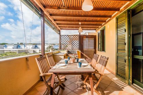 a dining room with a table and chairs on a balcony at Residence Andrea Doria in Marina di Ragusa