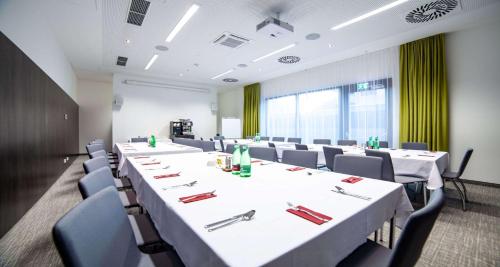 una sala de conferencias con mesas y sillas blancas en una habitación en Best Western Hotel Tulln en Tulln