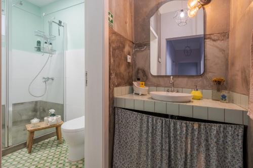 a bathroom with a sink and a toilet and a mirror at Endemic - Concept Apartment in Funchal